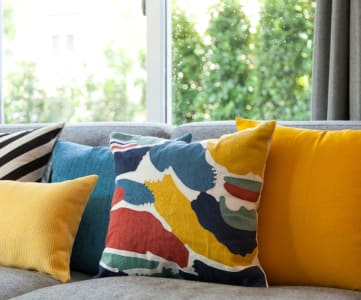 a group of pillows on a couch in front of a window