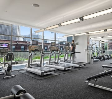 an image of a gym with treadmills and weights