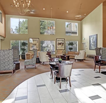 a large lobby with chairs and tables and windows
