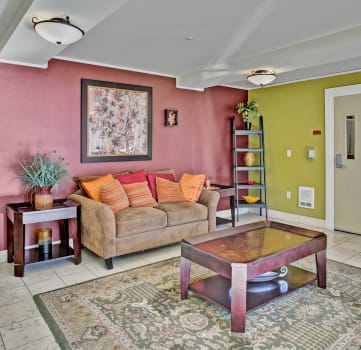 a living room with pink walls and a brown couch and a table
