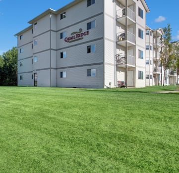 a large green lawn in front of an apartment building