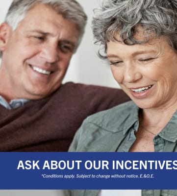 an older man and woman sitting on a couch   ask about our incentives