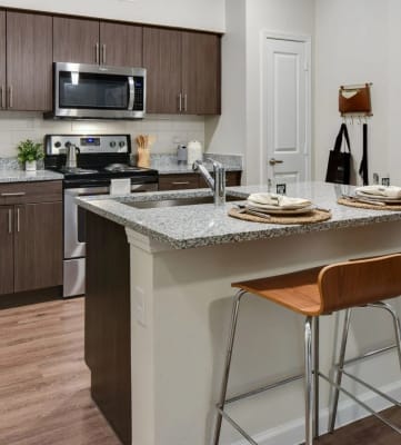 a kitchen with a counter top with bar stools