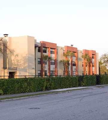 a row of apartment buildings with trees in front of them