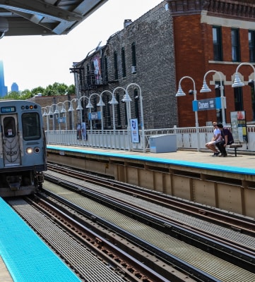 a train pulling into the station with the chicago skyline in the background