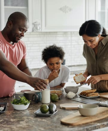 a family gathered around a kitchen counter preparing food
