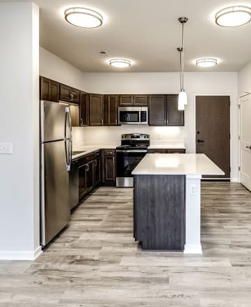 a kitchen with a large island and stainless steel appliances
