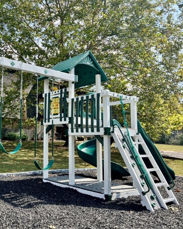 a playground with a swing set and a play house
