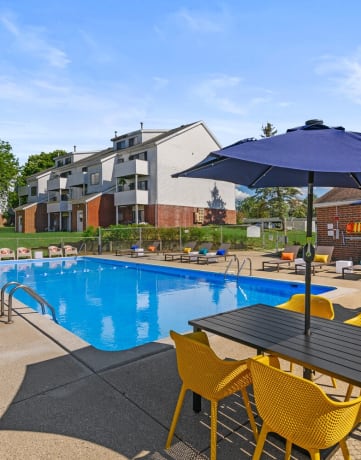 our apartments have a pool and patio with chairs and umbrellas