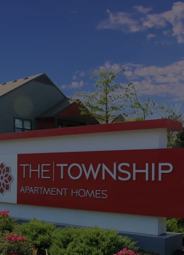 a sign that says the township i apartment homes in front of a house