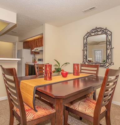a dining area with a table and chairs and a kitchen in the background at Arbors at Windsor Lake, South Carolina, 29223