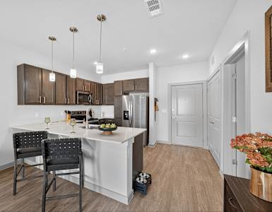 A kitchen with a white island and two chairs.