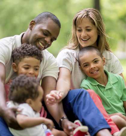 a family sitting on the grass with their children