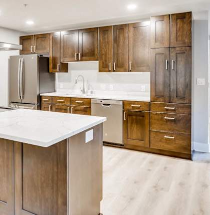 A modern kitchen with wooden cabinets and a white countertop.