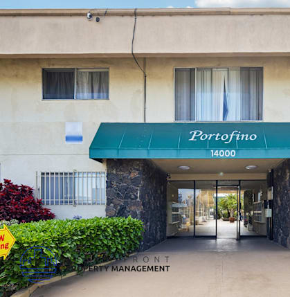 The entrance to a building with a green awning that says Porrofino.