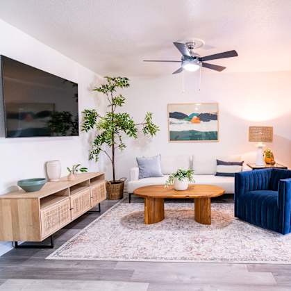 A living room with a blue couch and a wooden coffee table.
