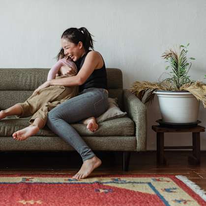 a woman sitting on a couch holding a baby