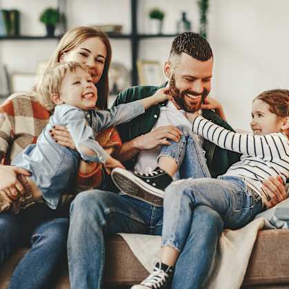 a family sitting on a couch with two children
