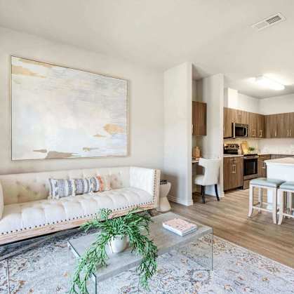 a living room and kitchen with a couch and a table