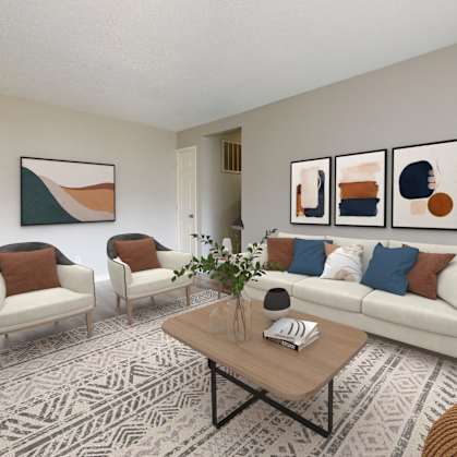 a living room with a couch and two chairs and a table