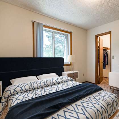 Bismarck, ND Brandon |a bedroom with a large bed with a blue and white comforter