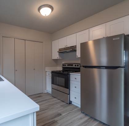 a kitchen with white cabinets and stainless steel appliances
