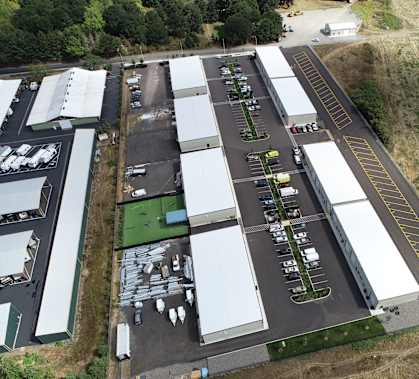 an aerial view of a building with a parking lot and grassy area