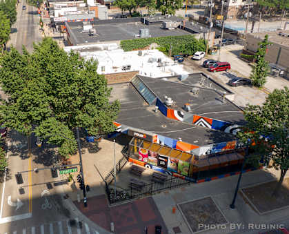 an aerial view of a city street with cars and trees