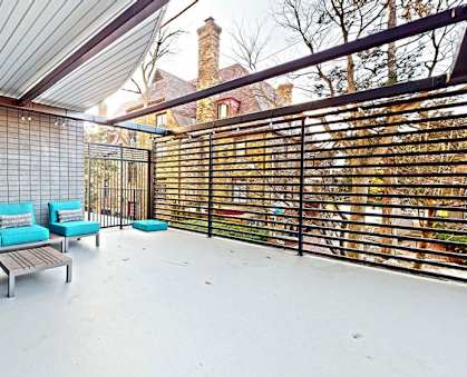 a patio with blue couches and a wooden coffee table