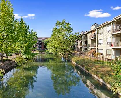 a canal surrounded by apartment buildings and trees