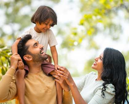 A family of three is enjoying a moment together outdoors.