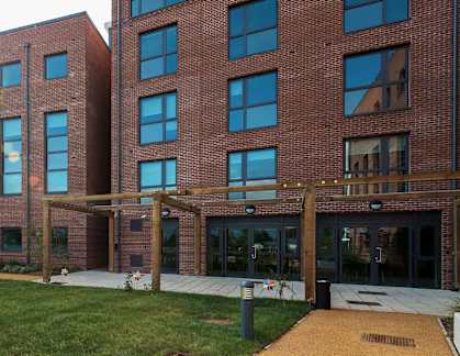 a large brick building with a grassy area in front of it