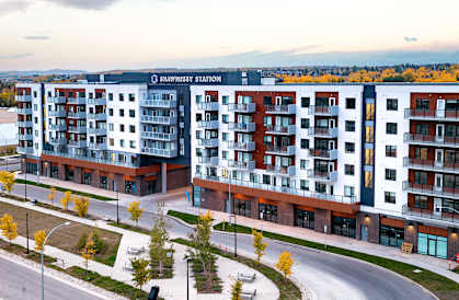 an aerial view of an apartment building with a highway in the foreground