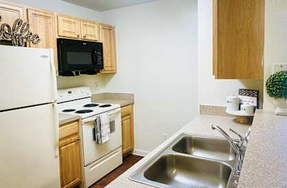 a kitchen with white appliances and wooden cabinets