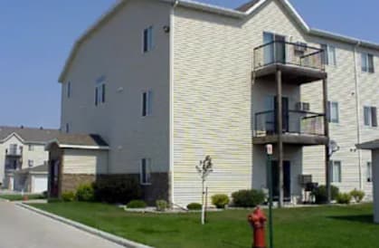 A fire hydrant is in front of a two-story apartment building.