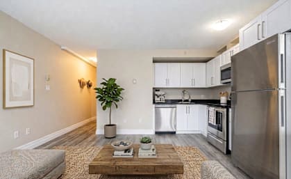 A modern kitchen with a refrigerator, microwave, and oven.