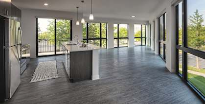 a large open kitchen and living room with a view of the outdoors