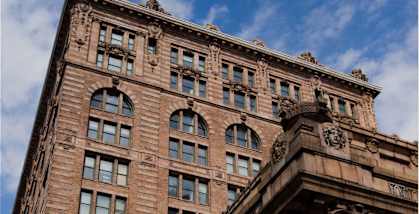 A tall brown building with many windows and decorative stonework. at The Pennsylvanian Apartments, Pittsburgh, Pennsylvania