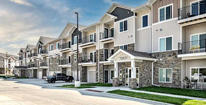 a row of apartment buildings with a truck parked in the driveway