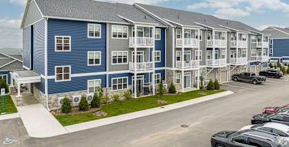 a large apartment building with cars parked in a parking lot