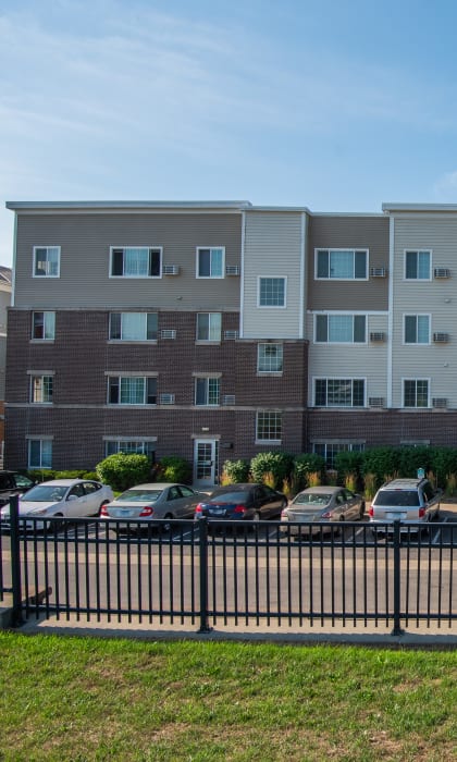 a large apartment building with cars parked in front of it