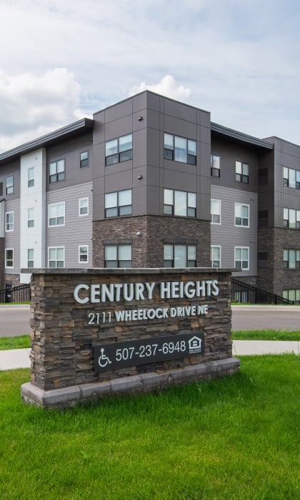 a large building on the side of a road with a sign in the grass
