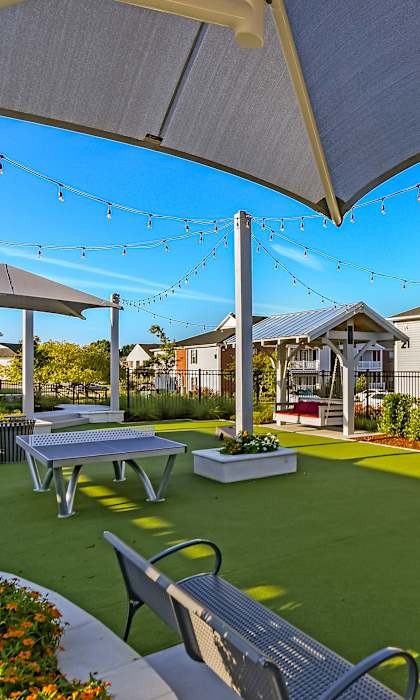 the backyard of a home with picnic tables and chairs