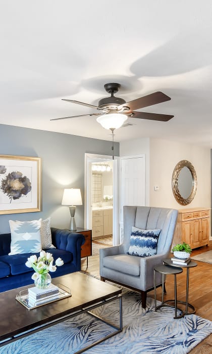 a living room with a blue couch and a ceiling fan at Bridgewater Apartment Homes, Brandon, 39047