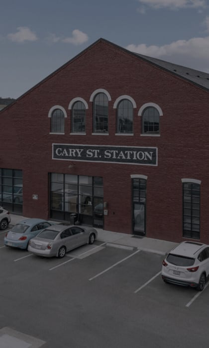 Cars are parked in front of a red brick building with a sign that says Cary St. Station.