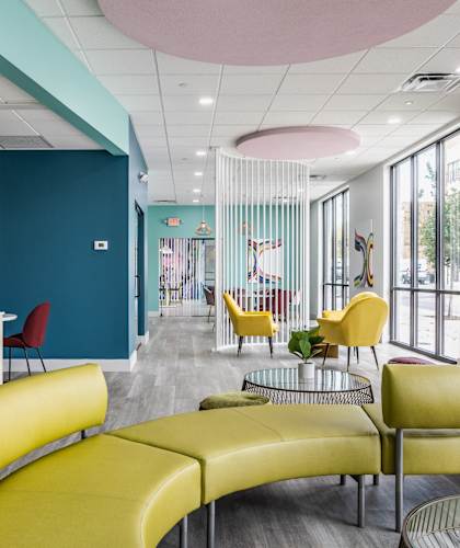 A room with a blue wall and yellow chairs.