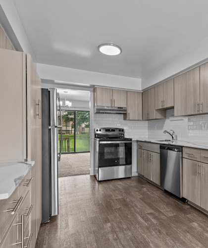 a kitchen with wooden cabinets and stainless steel appliances at Edge At Farmington Hills - Farmington Hills, MI, Michigan, 48334