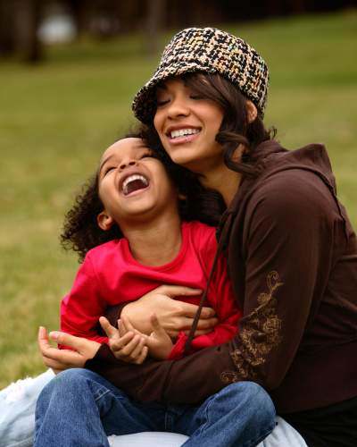 a woman and a child sitting on the grass