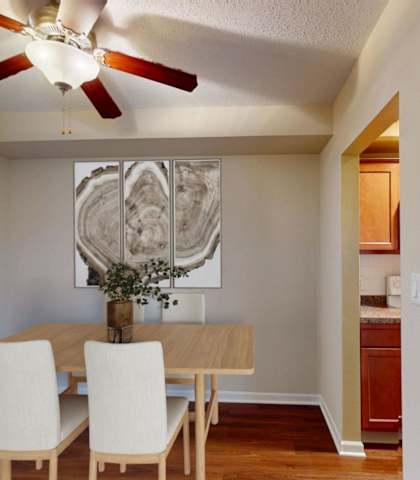 A dining room with a table and chairs and a ceiling fan.