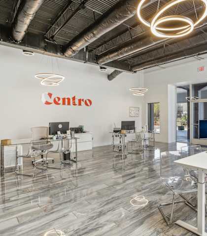 an open office with desks and chairs and a computer on a table